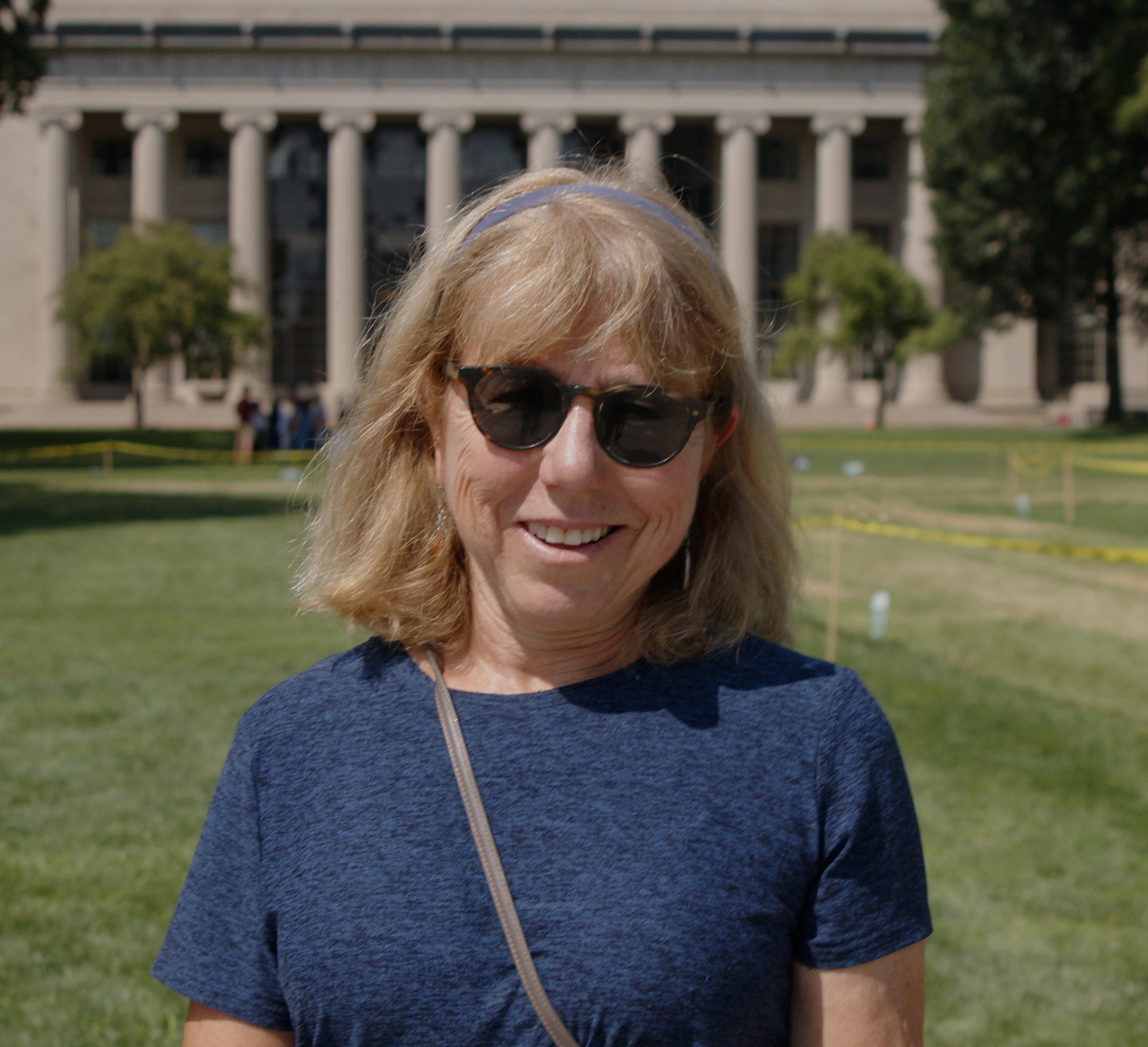 Debra Meyerson standing in Killian Court with the pillars of building 10 behind her