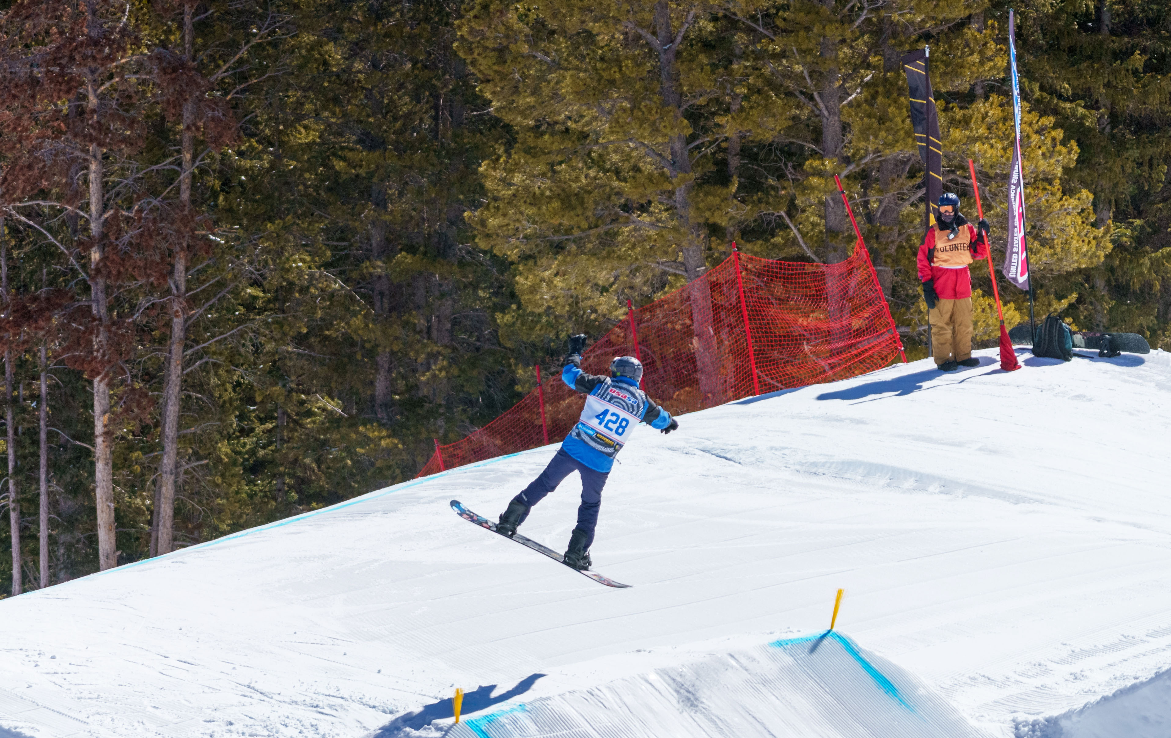 Dick Schulze on a snowboard going off a jump 