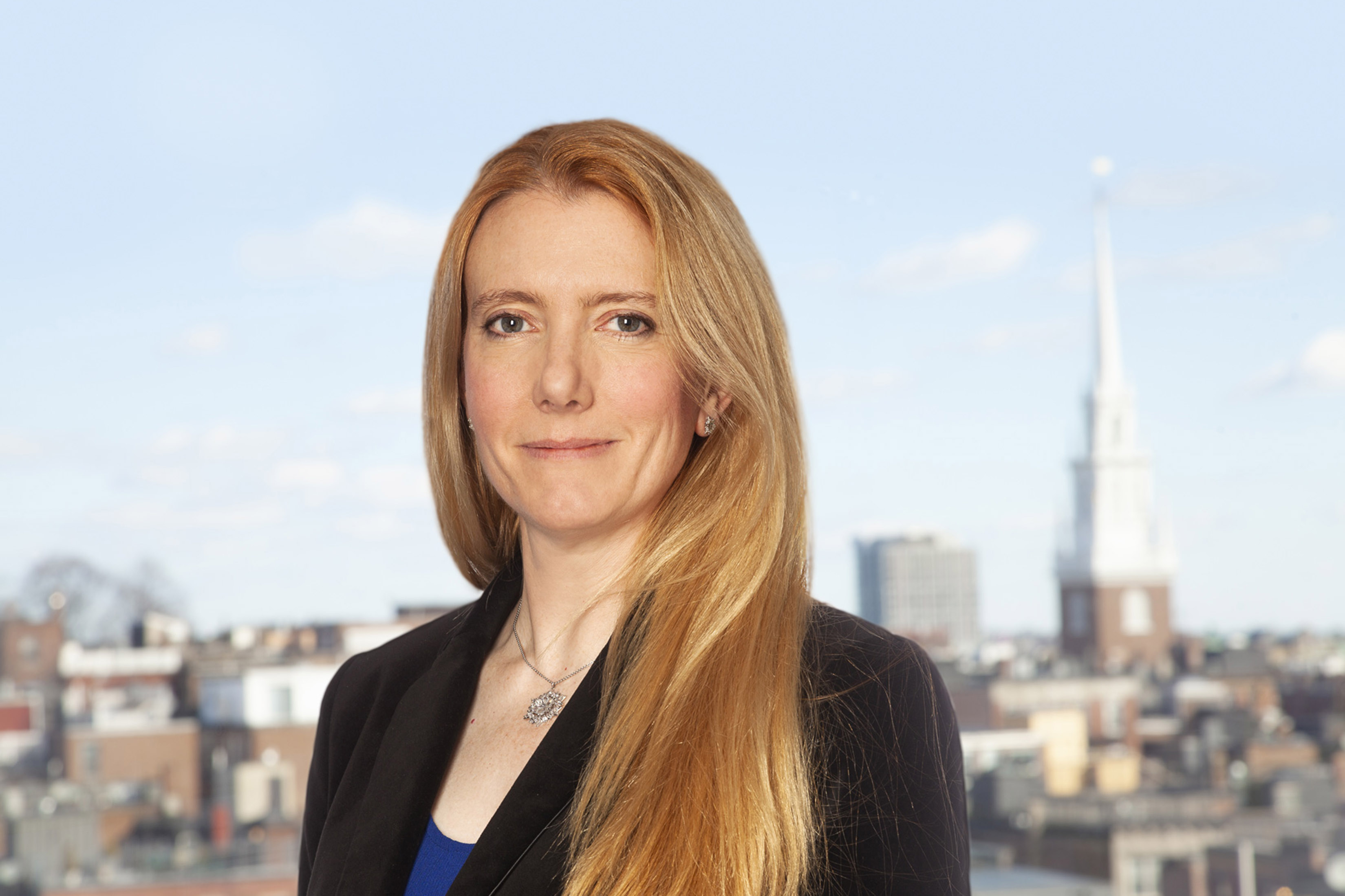 Rebecca Berry head-and-shoulders photo with city of Boston in background.