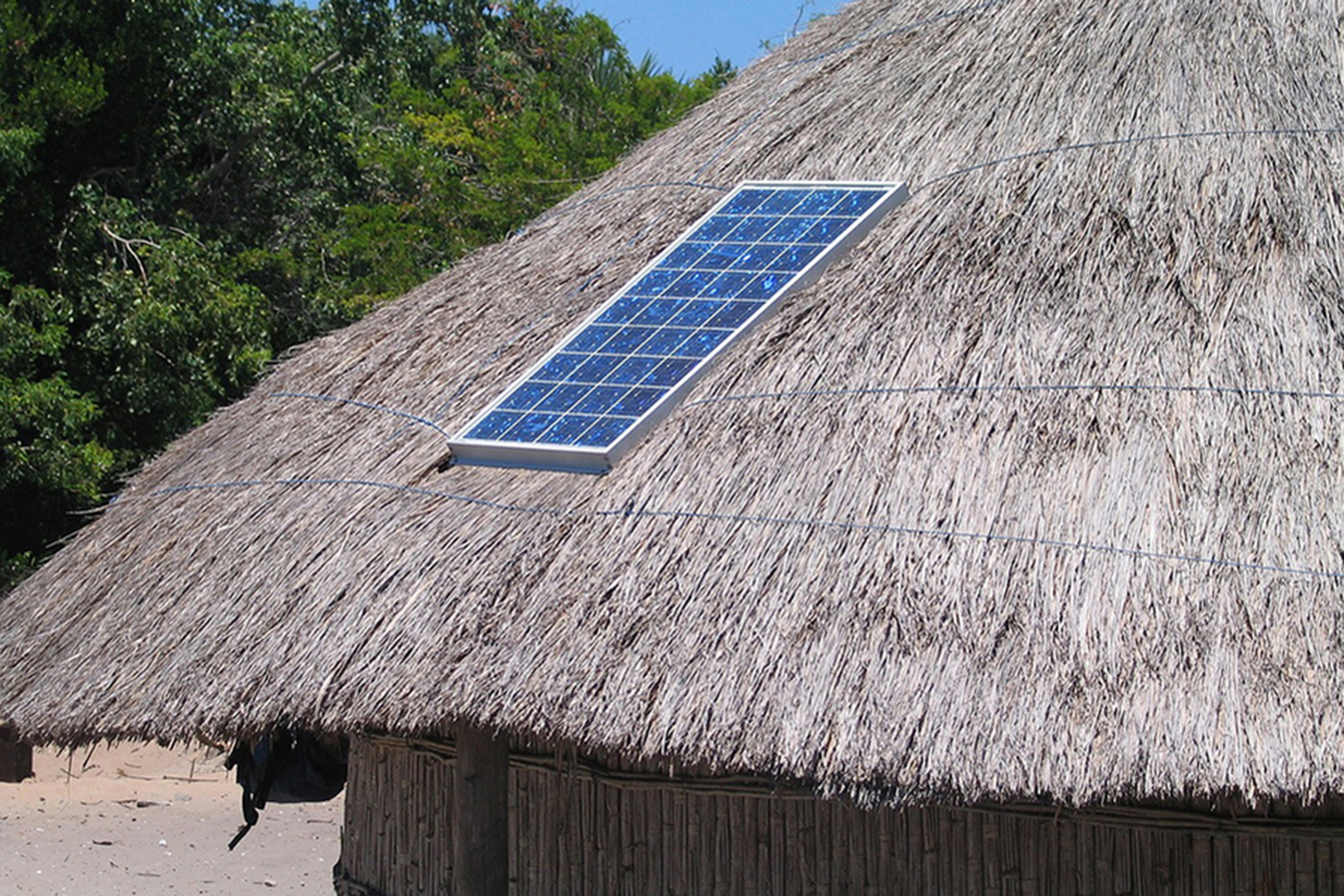 A solar panel is shown embedded in a grass roof.