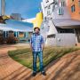 MIT alum Greg Falco standing in a courtyard outside in front of the MIT Stata Center